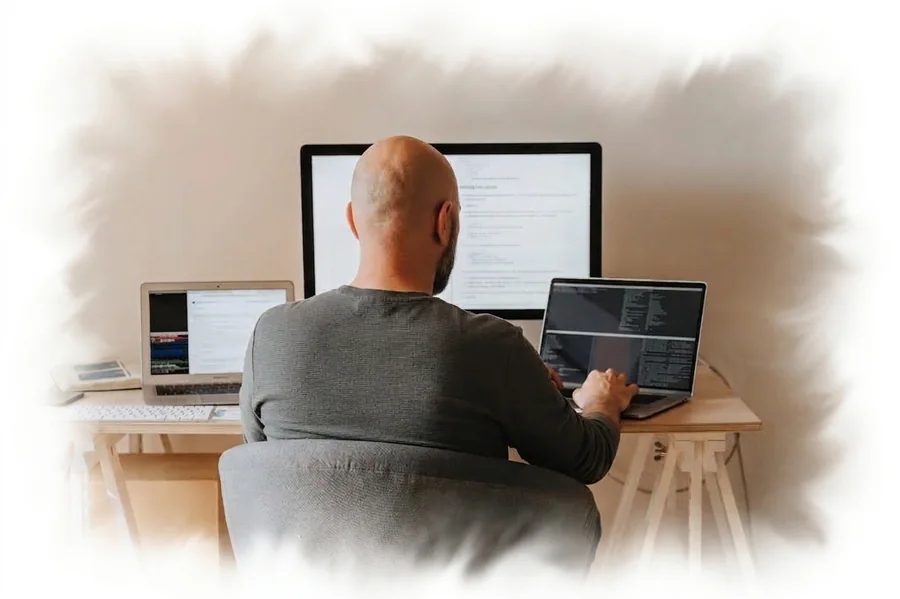 The founder at work — monitors, code and coffee
